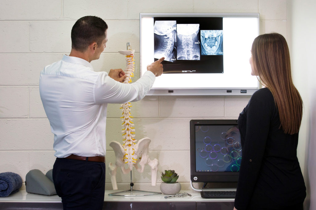Chiropractor checking patient's x-rays